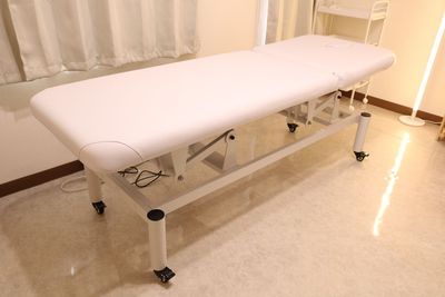 【電動昇降ベッド】フットペダルを踏むだけで高さは51cm～88cmまで調整可能
ガス圧式リクライニング（長さ約185cm×幅約65cm/マット厚約10cm） - FROM NOW（フロムナウ）五反田 レンタルサロンの設備の写真