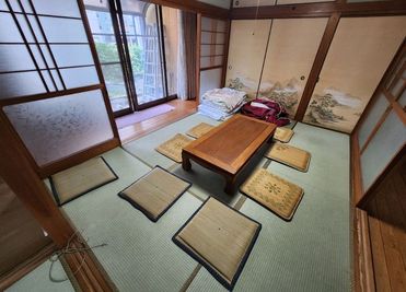6畳の和室と縁側、座卓と座布団 - KITAKYUBASE レンタルスペース 45平米の広々和室の古民家 レンタルスペースの室内の写真