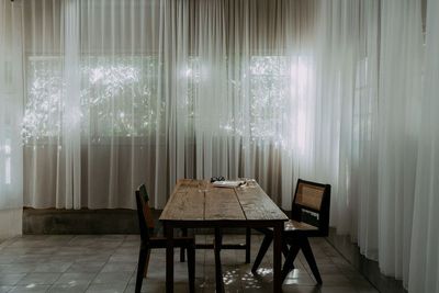 木漏れ日に揺れるカーテンと、静かな食卓のシーン - アンスピラシオン (Anspiration)  光に包まれた北欧の家の室内の写真