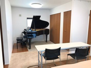 グランドピアノのスペースには椅子と机も完備しているので、数名が待機することも可能 - ot ACADEMY  レンタルスペース(ピアノ、料理)の室内の写真