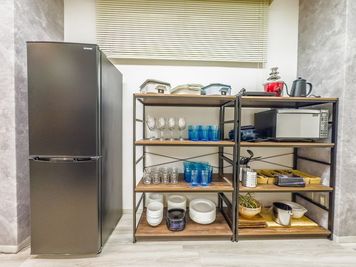 大型冷蔵庫、電子レンジ、備品棚 - エムズ新宿御苑 懇親会もできる貸会議室　LUXE新宿(2026年1月以降予約用)の設備の写真