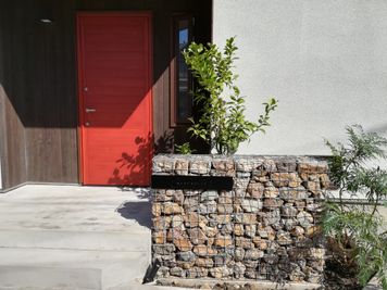 WAREHOUSEの石塀と赤い玄関扉を目印にお越しください！ - 逗子の開放的なMTGスペース 逗子の開放的なMTGスペース（WAREHOUSE Zushi）の入口の写真