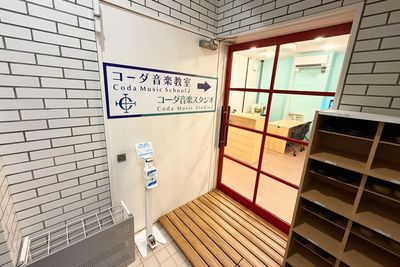 コーダ音楽スタジオの入口。赤いドアと看板が目印で、入ってすぐ左側に受付があります。 - コーダ音楽スタジオ クラシック向け防音スタジオ【Aスタジオ】の入口の写真