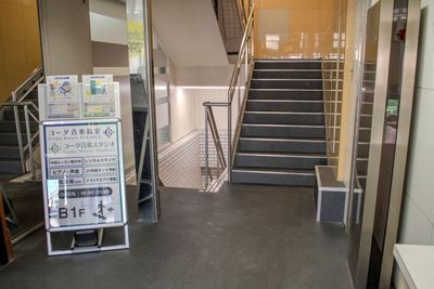 B1Fへのスタンド看板が目印。階段を降りて正面がコーダ音楽スタジオの受付です。 - コーダ音楽スタジオ クラシック向け防音スタジオ【Aスタジオ】の入口の写真
