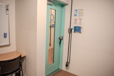 Cスタジオの出入口周辺。注意事項とスタジオタイマーがあり、入退室や利用時間がわかりやすい配置です。 - コーダ音楽スタジオ クラシック向け防音スタジオ【Cスタジオ】の室内の写真