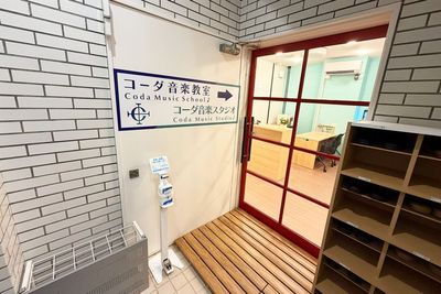 コーダ音楽スタジオの入口。赤いドアと看板が目印で、入ってすぐ左側に受付があります。 - コーダ音楽スタジオ クラシック向け防音スタジオ【Cスタジオ】の入口の写真