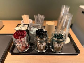 ミルクやシロップ、お砂糖もご用意ございます。お好みの組み合わせでお楽しみいただけます。
※ドリンクスティックは時期によってフレーバーが異なることがございます - BasisPoint 八王子店 【8名会議室RoomB】八王子エリアの設備の写真