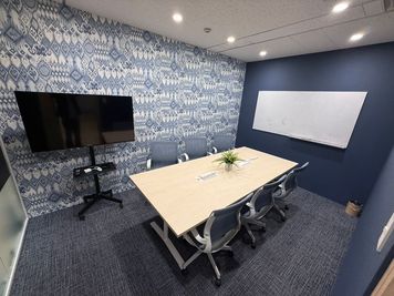 ・中会議室
・6〜8名がけテーブル×1
・ホワイトボード×1
・大モニター×1
・延長コード電源タップ×2 - ミートアップカフェ西新宿 6〜8名セミナー/研修/会議スペース（中会議室）の室内の写真