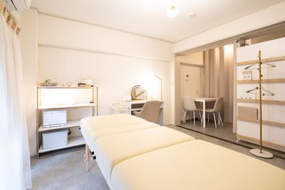広めなお部屋です。施術ベッド、メイクスペース兼ネイルデスク、テーブルやチェアをご利用いただけます。 - レンタルサロンStella元町店の室内の写真