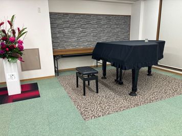 グランドピアノの後ろの壁にアクセントを兼ねて湿度調節タイルを張り、調律の安定に努めています。 - TSD音楽練習室　Freunde 一階　ホールの室内の写真