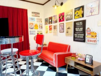 チェック柄の床、壁面には50’ｓなレコードジャケットやポスター、ブリキ看板などが雰囲気を盛り上げます。
 - アメリカンダイナースタジオ糸崎 【5名様以上はこちら】アメリカンダイナースタジオ糸崎の室内の写真
