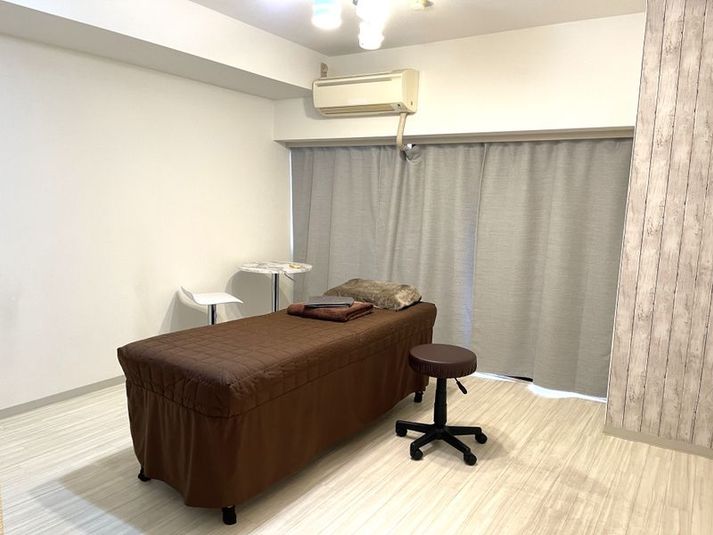 ベッド・スツール・丸テーブル・イス
備品（枕・バスタオル・ペーパーシーツ） - 【AngelSalonグループ】iley川崎店 【完全個室】レンタル美容サロンの室内の写真