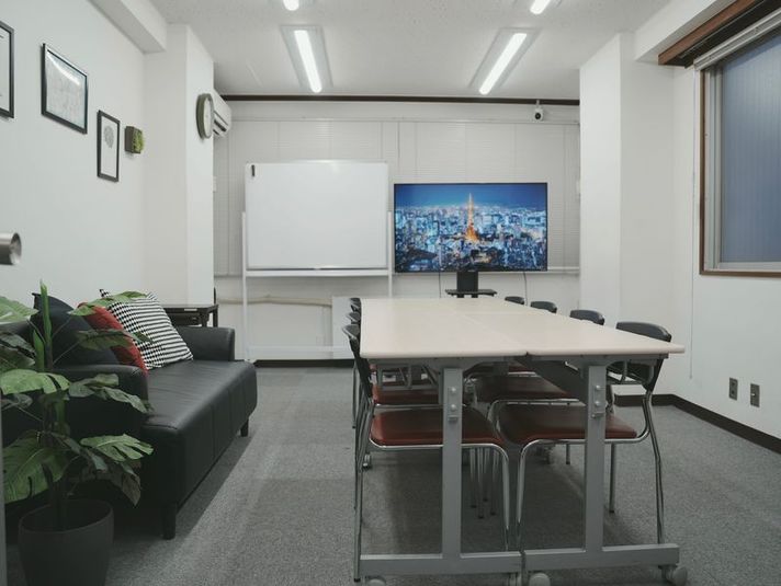 2人掛けデスク×4台　椅子10脚　50型モニタ　ホワイトボード - 高速Wi-Fi完備 神保町会議室 高速Wi-Fi完備 神保町会議室 TA Rental Spaceの室内の写真