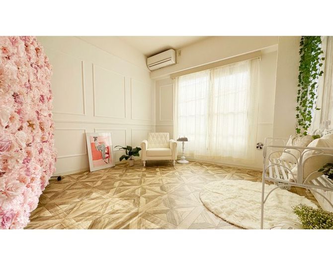 自然光が柔らかく差し込む撮影スタジオ。左側はモールディングの白壁、可動式のバラ壁、右側は白アイアンベンチとグリーンを取り入れたナチュラルガーデン風。 - ライラスタジオ駒沢 【渋谷・三軒茶屋エリア】駅チカ・自然光×白壁×バラ撮影スタジオの室内の写真