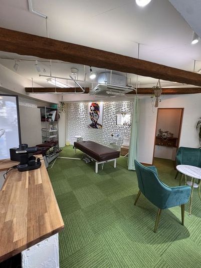 施術用ベッド、受付カウンター、ソファ席が配置された広々としたスペース内観 - プロ仕様レンタルサロンBIKOTSUSEIDO PARIS 【OPENSALE】ゼニス電動昇降式ベッド完備プロ専用カイロ整体の室内の写真