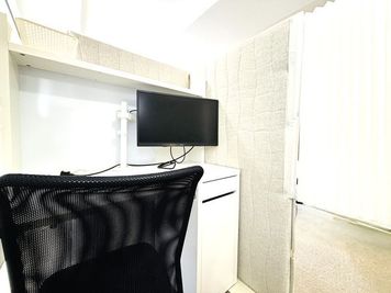 ブース内はモニターを設置。机の引出しは手荷物入れとしてご利用いただくことが可能です。 - いいオフィス渋谷東byWealthParkRET Room4（半個室:吸音型パーテーション仕切）の室内の写真