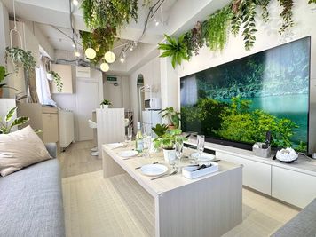 大迫力の75インチテレビは、推し活･映画鑑賞･スポーツ観戦にもオススメです。 - リーフラウンジ上野 【リーフラウンジ上野】ボタニカルホワイトカフェ風スペースの室内の写真