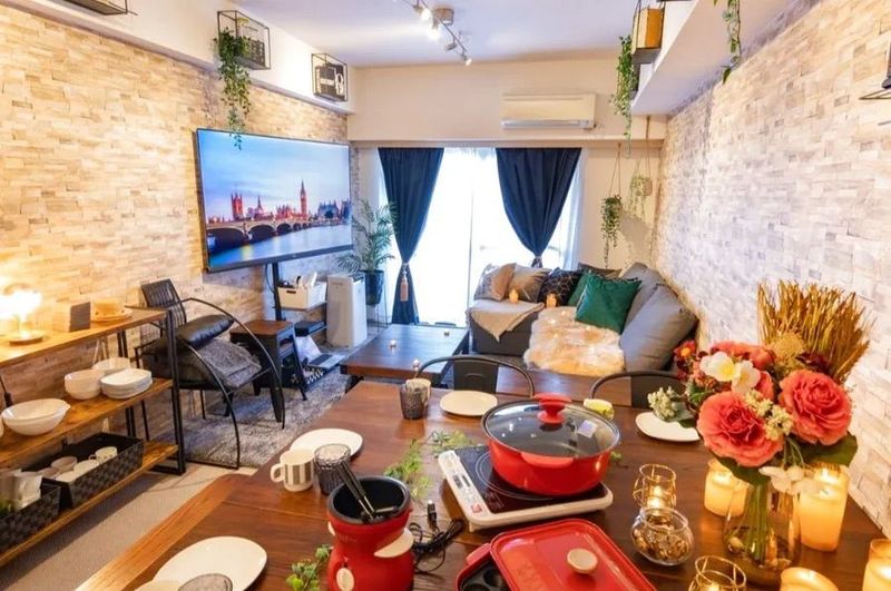 ゆったりくつろげるソファと広々としたテーブルを備えた空間。65型テレビで映画鑑賞やゲーム、女子会・バースデーをお楽しみいただけます。 - 渋谷原宿 Lounge レンタルルーム　最大9名・大型TV・大人気ゲームの室内の写真