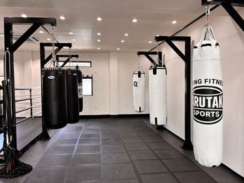 サンドバッグ - BOXINGFITNESS MARUTAKASPORTS 広々した空間、大きな鏡、ダンスもできるボクシングジム更衣室付きの室内の写真