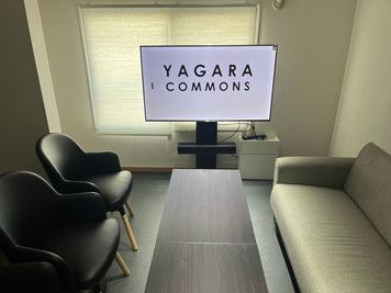【レイアウト】中央の長テーブルを挟み、ソファーとチェアでゆったり着席可能。 - YAGARA COMMONS ソファーミーティングルームの室内の写真