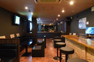 店内座席風景、奥にはダーツフロアあり - community＆darts BAR BORDERBREAKの室内の写真