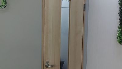 店内の木目の扉が予約対象の1名用半個室です。 - セルフカフェ千歳烏山店 1名用半個室の入口の写真