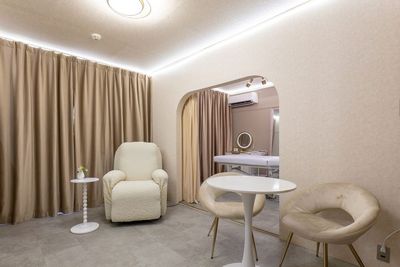 リクライニングチェアと丸テーブルを備えた手前のお部屋 - レンタルサロンeku　東梅田店 Re:room 東梅田｜完全個室レンタルスペースの室内の写真
