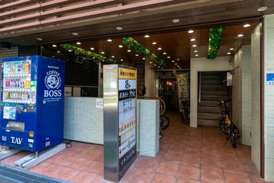 ビル1階のエントランス。自動販売機が目印です。右側の階段を登って4階になります。 - レンタルサロンeku　東梅田店 Re:room 東梅田｜完全個室レンタルスペースの入口の写真