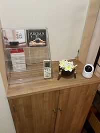 BGM用CD、和SPA、AROMAII、（他CD追加予定）
エアコンリモコン
ココナッツの小物入れにプルメリアの花がいっぱい
防犯カメラ - のんびりサロン 五反田店の入口の写真