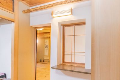 障子の小窓と丸太の梁。開口部の奥には、掛け軸を掛けた床の間が見えます。 - 千代田ヴィレッジ 板の間の和室2間＋中庭｜和装コスプレ・古民家風撮影の貸切スタジオの室内の写真
