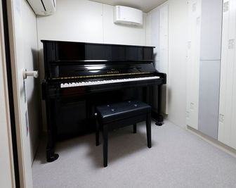 防音ルームにはアップライトピアノ1台を常設 - こどもでぱーと 自由が丘の室内の写真