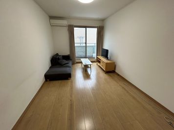 バルコニーに面した窓から光が入る、奥行きのある明るいお部屋です。 - Bed&City 北池袋 レンタルスペース 302号室｜大きなカウチソファでくつろげる完全個室の室内の写真