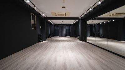 入口側から奥を見たところ。右の壁が鏡、左が黒い壁、奥のカーテンの中が更衣室です - レンタルスタジオEdge Voice（エッジボイス） 西長堀駅3分｜1フロア1室のダンス・ヨガ・撮影スタジオの室内の写真
