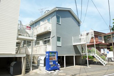 グレーの外観のアパートです。自販機も設置されているので喉が渇いても安心です！ - mamespaceの外観の写真