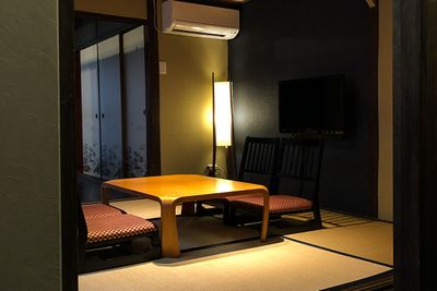 １階の居間には壁掛けテレビと座卓、座椅子が置いてあります - 京小宿　古川みやび 京町家レンタルスペースの室内の写真