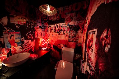 全面デザインクロスのトイレは、あえて暗いライトと赤のネオンライトを使用しアンダーグラウンドなイメージにぴったりです。 - Photo Studio NY 撮影スタジオの室内の写真