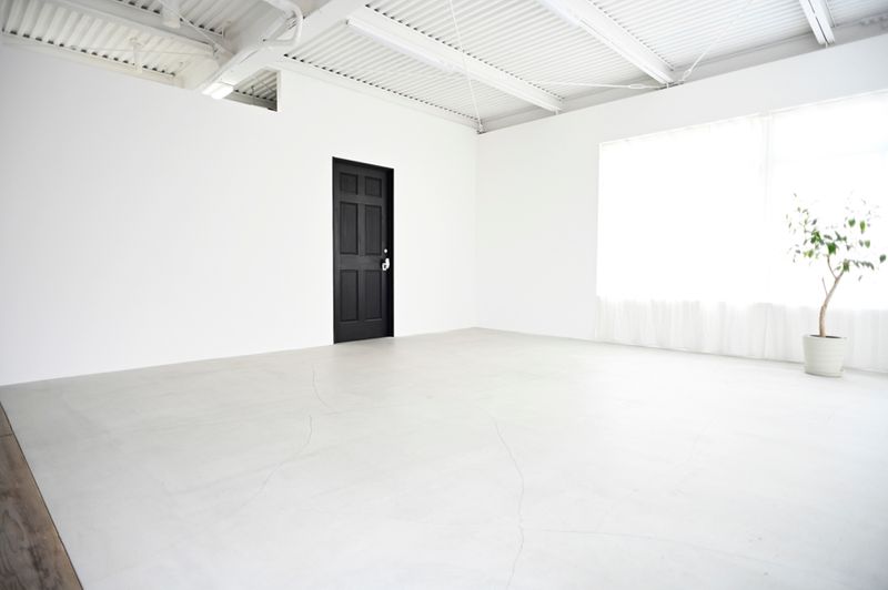 無垢の黒いドアの左右に広がる白壁（このドアはスタジオ事務所なので開けられません） - モーベター フォトスタジオの室内の写真