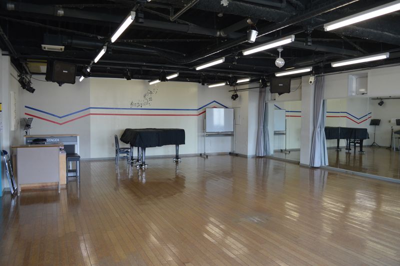 グランドピアノ・エレクトーン・ＰＡ完備、床もダンスやバレエに最適なクッションのある木製床、客席は１２０席まで収容可能 - ヤマハウイング北勢堂ビル内 多目的スペース　ホールの室内の写真