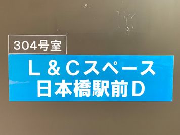 扉に看板を掲げています。ドアノブにキーボックスがあります。 - L&Cスペース日本橋駅前 D号室の入口の写真