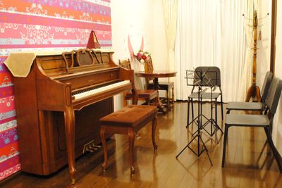 猫足の可愛いアップライトピアノ。椅子と譜面台は３つずつ。後ろの壁紙も可愛いので写真撮影にも最適です。 - レンタルスタジオ川和ONE レンタルスタジオの室内の写真