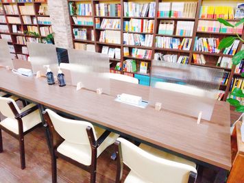 壁面全体に本が陳列されています。テーブル席は４×３の１２席です。 - 大崎ブックカフェ 大崎駅徒歩５分のレンタルスペースの室内の写真