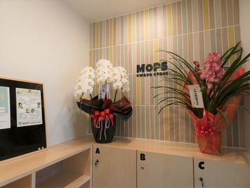 エントランスにはMOPSのロゴがお出迎え。
インフォメーションボードが設置されており、施設利用についてのお願いなどMOPSからのお知らせ等が掲示されています。
 - MOPS owada space レンタルスペースの入口の写真