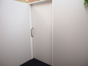 背景となる入口扉も壁も真っ白なので、ウェブ会議にもピッタリです。 - ROUGHLABO TECH扇町 【ROUGH LABO TECH扇町】コワーキング個室ブースの室内の写真