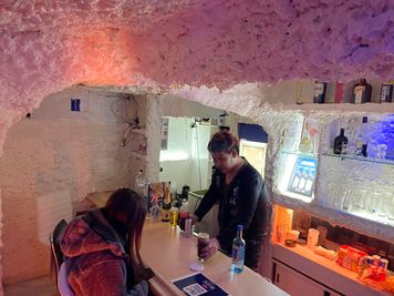 壁には100年前の珊瑚礁を原料にした素材が。冬は暖かく夏は涼しい空間です。 - 六角河原町ビル201cafe&barAqua 60型モニターカラオケ完備『cafe＆barAqua』の室内の写真