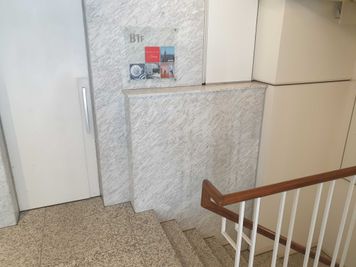 こちらの階段より地下1階へお進みください。 - New York Art Galaxy 貸し会議室・イベントスペースの外観の写真