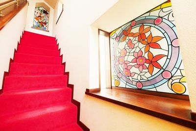玄関を入ってすぐの階段は、ステンドグラス窓や赤い絨毯が、映えます。 - 祐天寺アトリエ 【５１名以上でご利用の方用】ペット可ゆったり25帖キッチン付の室内の写真