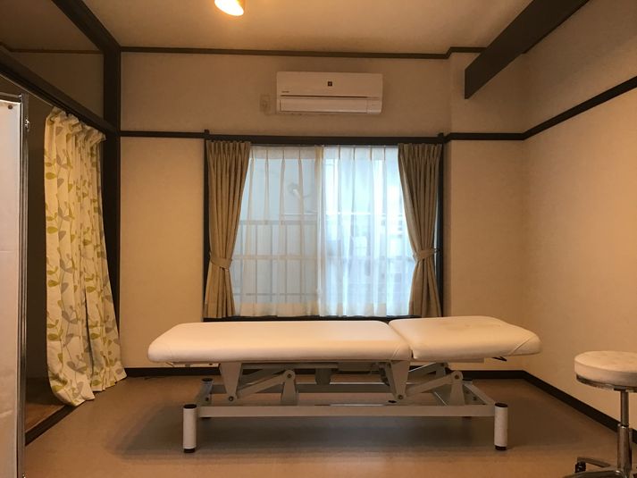 ベッド中心にした部屋全体。左手に見えるカーテンの奥が更衣室になっています。 - therapist's studio からだすまいる本舗 ２階レンタルサロンの室内の写真