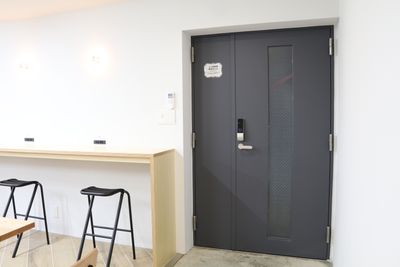 【カウンター席の横にあるドアはマンションご入居者様専用の出入口です。一般のお客様はご利用いただけませんのでご注意ください】 - 【閉店】TIME SHARING WORK 綱島 オープン席の室内の写真