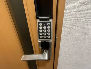 【ドアノブについた黒いカバーを開くと数字がかかれたボタンがありますので、暗証番号を押して開錠してください。暗証番号はご予約完了メールに記載しております】 - 【閉店】テレワークブース御徒町 ALビル 【閉店】ブース001の入口の写真