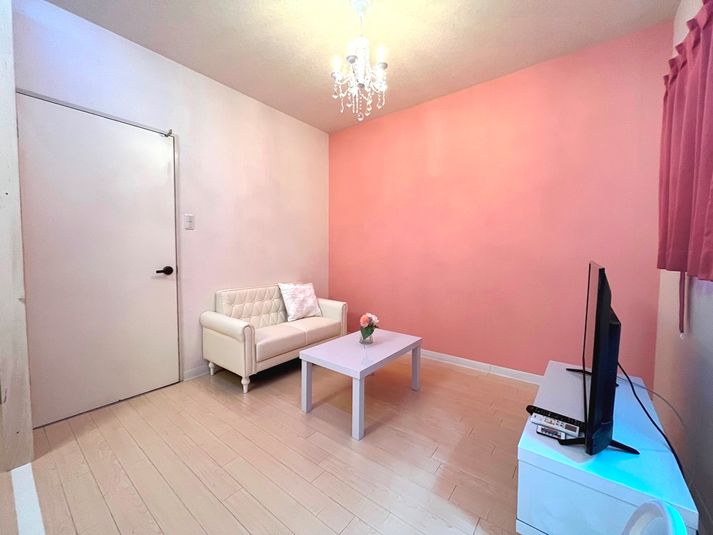 2人掛けのホワイトソファーにピンクの壁を背景の撮影などに適しています。 - グランデール栄B棟１F 【リバーリッチ】グランデール栄B棟１Fの室内の写真